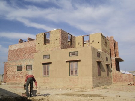 The built space against the April sky. Here one can see the contrast of the exposed adobe on the 1st floor against the plastered adobe on the ground floor.